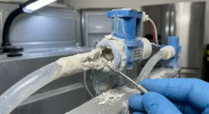 Technician inspecting calcified refrigerator ice maker components caused by hard water mineral buildup in Sunrise FL